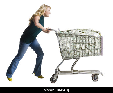 Frau mit einem Einkaufswagen voller Geld Stockfoto