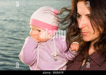 Mutter, 32 Jahre und ihr kleines Mädchen 9 Monate und Wasserstand außerhalb Stockfoto