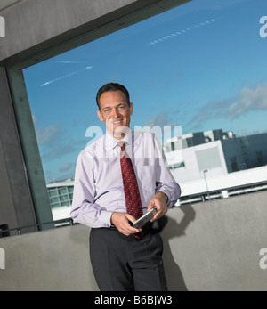 Porträt des Kaufmanns Wand gelehnt und lächelnd Stockfoto