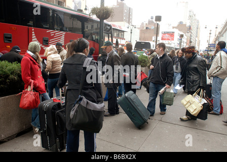 Reisende warten auf Linie der preiswerte MegaBus außerhalb der Pennsylvania Station in New York an Bord Stockfoto