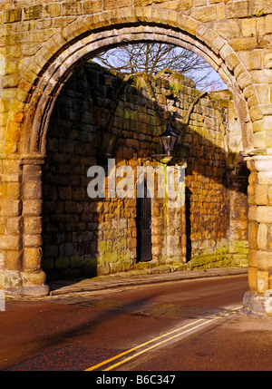 moderne Fahrbahn durch St Wilfrid Tor mittelalterliche Stein Torbogen in der Nähe von Hexham Abbey Stockfoto