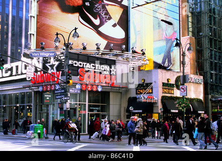 Shopper in New York City an einem geschäftigen Wochenende auf der Seventh Avenue. U-Bahn-Eingang. Straßenszene USA Stockfoto