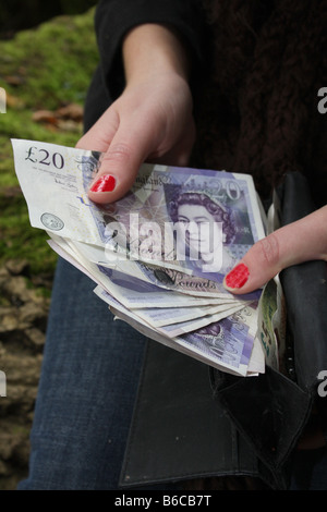 Eine Frau hält einige englische Pfund Sterling. Stockfoto