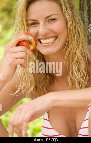 Porträt der Frau hält Apfel lächelnd Stockfoto