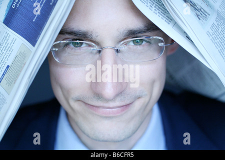 Nahaufnahme der Geschäftsmann mit Zeitung auf dem Kopf und lächelnd Stockfoto