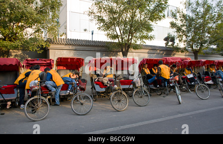 CHINA BEIJING Linie rot überdachte chinesischen Rikschas oder Fahrradrikschas und ihre Fahrer Stockfoto