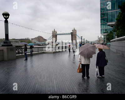 Besucher im Regen Tower Bridge London Touristen Sonnenschirme Stockfoto