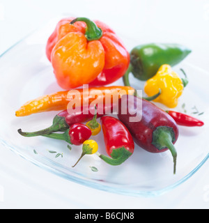 Nahaufnahme von grünen und roten Chilischoten auf Platte Stockfoto