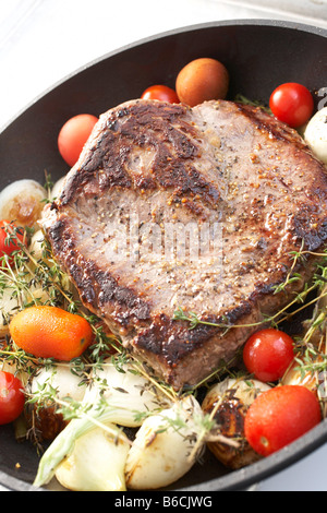 Nahaufnahme von gebratenem Fleisch mit Tomaten in der Pfanne Stockfoto