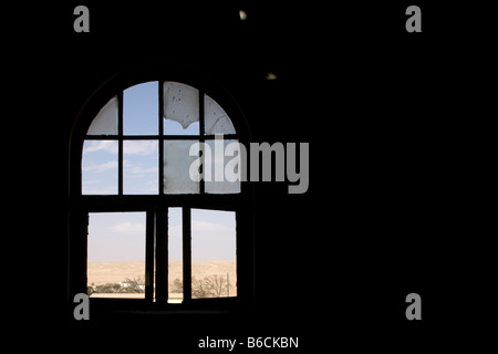 Afrika Namibia Kolmanskop Blick durch zerbrochenes Fenster in der alten verlassenen Gebäude in Geisterstadt Diamant Bergbaustadt Stockfoto