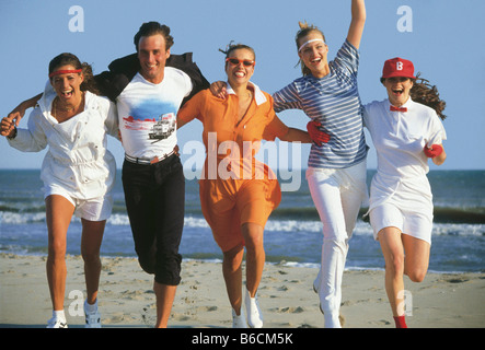 Vier junge Frauen und junge Mann läuft am Strand Stockfoto