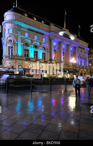 Beleuchtetes Londoner Trocadero-Gebäude viktorianische Barockfassade im Inneren des Unterhaltungs- und Einkaufskomplexes farbenfrohe Lichter, die sich in nassen Straßen Großbritanniens widerspiegeln Stockfoto