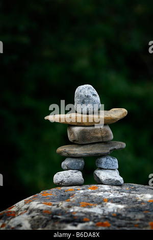 Inuksuk aus Flusssteine gegen einen Wald gemacht. Stockfoto