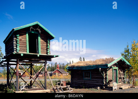 Burwash Landung am Kluane Lake, Yukon Territorium, Kanada - Lebensmittel-Cache und alte Blockhütte mit Sod Dach, Klondike Region Stockfoto