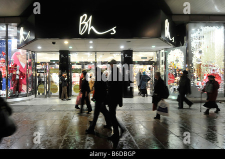 London Oxford Street Silhouette Shopper zu Fuß auf nassen Bürgersteig West End BHS British Home Stores Einzelhandel Geschäft Geschäft Front Schild UK Einkaufsstraße Stockfoto