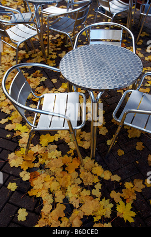 Tische und Stühle vor einem Café in Worcester, Großbritannien, umgeben von Herbstlaub Stockfoto