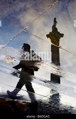 Nelsons Säule und Figur spiegelt sich in Pfützen. Trafalgar Square, London, England, UK Stockfoto