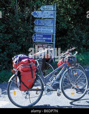 Ballylickey, Beara Halbinsel, county Cork, Irland, touristische Fahrräder mit Gepäcktaschen parkte vor Wegweiser im ländlichen Irland Stockfoto