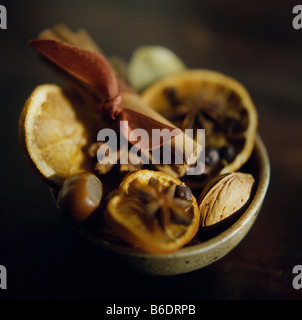 Pot-Pourri. Getrocknete Gewürze, Zitrusfrüchte-Scheiben und Muttern in einer Holzschale als eine Haushaltsdekoration. Stockfoto