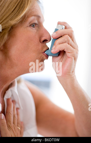 Asthma-Inhalator verwenden. Frau mit einem Inhalator, um einen Asthma-Anfall zu behandeln. Stockfoto