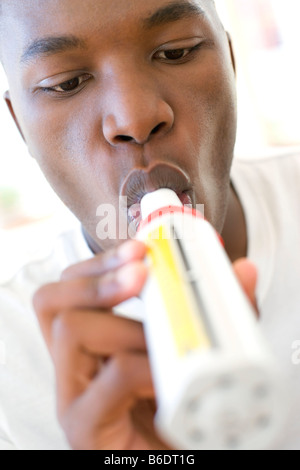 Mann bläst in ein Peak-Flow-Meter, sein Asthma zu überwachen Stockfoto