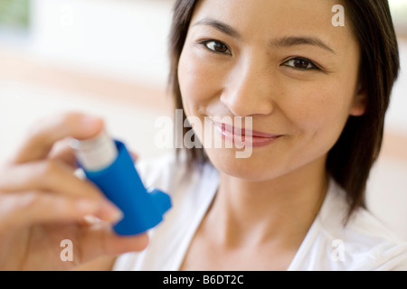 Asthma-Inhalator verwenden. Frau mit einem Inhalator, um einen Asthma-Anfall zu behandeln. Der Inhalator enthält bronchienerweiternde Medikamente. Stockfoto