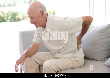 Mann reibt seinen schmerzenden Rücken Stockfoto