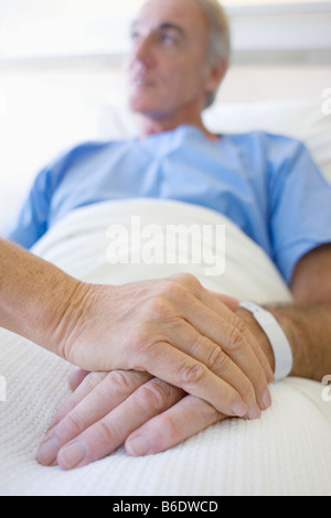 Besuch im Krankenhaus. Frau mit ihrem Partner Hand in ein Krankenhaus zu besuchen. Stockfoto