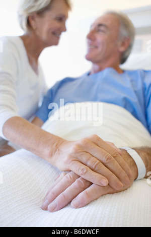 Besuch im Krankenhaus. Frau mit ihrem Partner Hand in ein Krankenhaus zu besuchen. Stockfoto