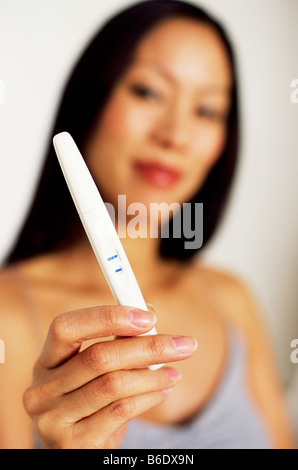 Positiven Schwangerschaftstest. Frau mit einem Schwangerschaftstest-Stock, der ein positives Ergebnis angezeigt wird. Stockfoto