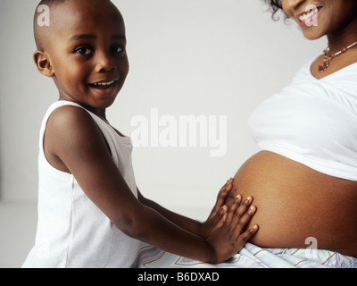 Schwangere Frau und Sohn. 4-Year-Old Boy berühren den geschwollenen Bauch seiner Mutter. Stockfoto