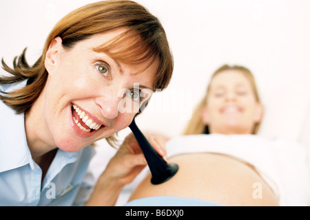 Geburtshilfliche Untersuchung. Hebamme mit einem Pinard gedrückt, um einer schwangeren Bauch. Stockfoto