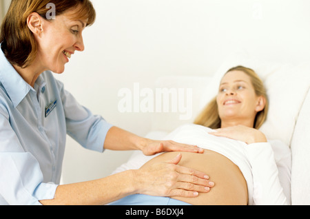 Geburtshilfliche Untersuchung. Midwide Abtasten einer schwangeren Bauch um die Position des Fötus zu bestimmen. Stockfoto