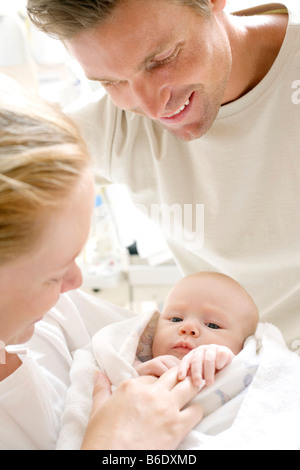 Eltern und Neugeborene. Mutter und Vater in einer Entbindungsstation halten ihre neugeborenen Babys. Stockfoto