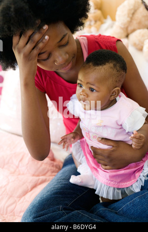 Teenager-Mutter und Baby. Junge Mutter hält ihr 4 Monate alte Tochter betonte. Stockfoto