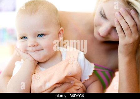 Teenager-Mutter und Baby. Junge Mutter hält ihr 10 Monate alte Tochter betonte. Gestellt von Modellen. Stockfoto