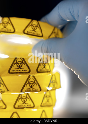 Biohazard-Warnung. Wissenschaftler eine Petrischale aus einem Stapel aufnehmen. Die Petrischalen Aresealed mit Biohazard Warnung Klebeband. Stockfoto