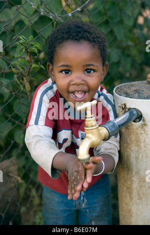 Südafrika, Johannesburg, Soweto, Slums und squatter Camps. Junge Hände waschen Stockfoto