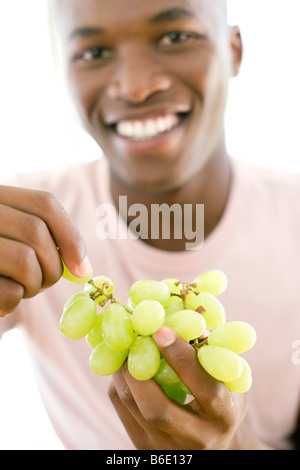 Gesunde Ernährung. Mann isst Weintraube. Stockfoto