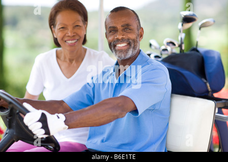 Golf-Spieler. Mann und Frau mit einem Golfwagen während einer Runde Golf. Stockfoto