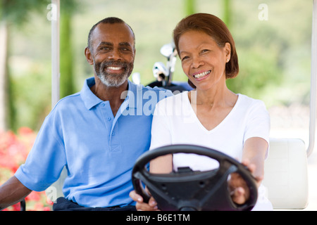 Golf-Spieler. Mann und Frau mit einem Golfwagen während einer Runde Golf. Stockfoto