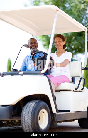 Golf-Spieler. Mann und Frau mit einem Golfwagen während einer Runde Golf. Stockfoto