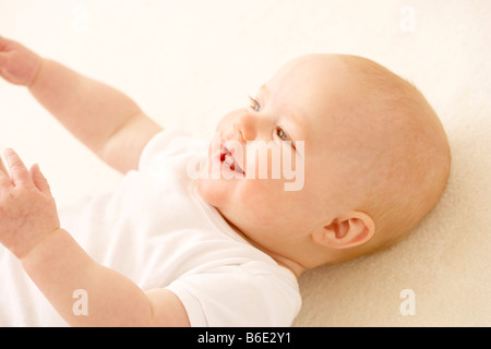 Babymädchen auf dem Rücken liegend Stockfoto