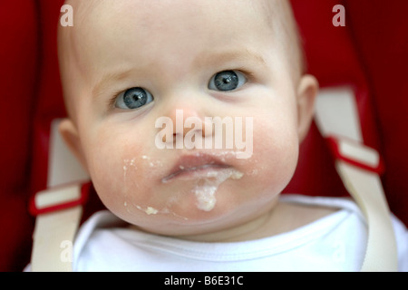 Babymädchen (6-11 Monate) mit Essen rund um den Mund Stockfoto