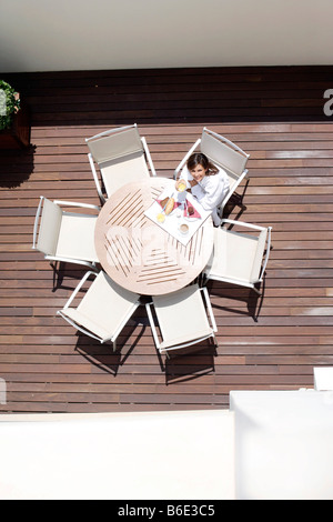 Frau am Tisch im Freien frühstücken Sie auf Hotelterrasse Stockfoto