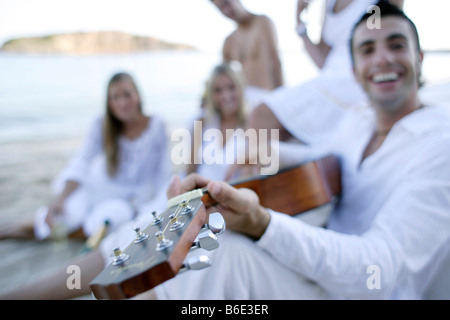 Junger Mann, die Gitarre für Freunde Stockfoto