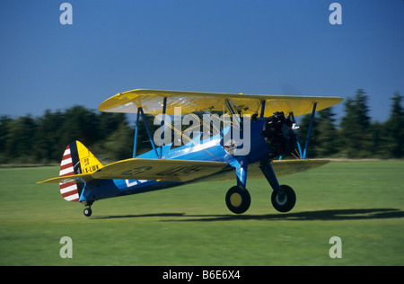 Alte amerikanische Trainer Doppeldecker Boeing PT-17 Kaydet / Stearman Modell 75 Landung auf einem grünen Rasen-Flugplatz Stockfoto