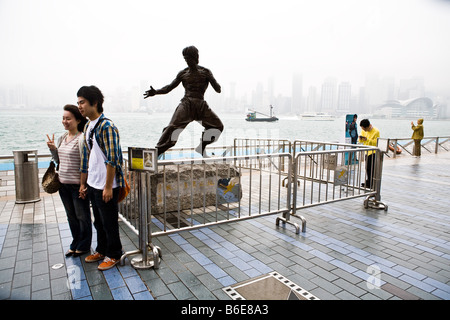 Touristen posieren vor der Statue von Bruce Lee in Tsim Sha Tsui entlang der Uferpromenade in Hongkong China Stockfoto