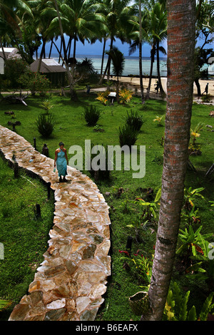 Eine Frau geht auf einen Stein Weg Coconuts Beach Club in Samoa auf der Insel Upolu Stockfoto