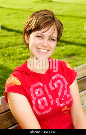 Glückliche junge Frau trägt einen roten Kapuzenpullover Stockfoto